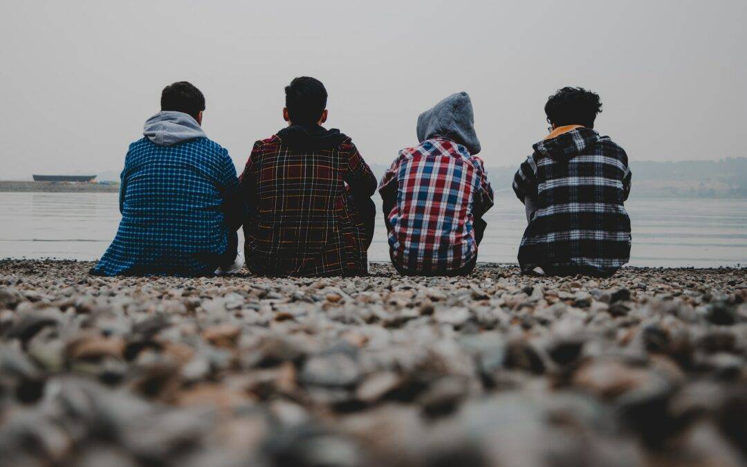 un gruppo di ragazzi di spalle guarda il mare, in un tempo sospeso, con la paura del fallimento