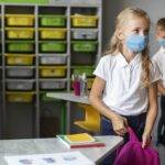 Bambini a scuola con mascherina, causa lockdown