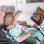 lettura di un libro illustrato di un genitore al figlio neonato